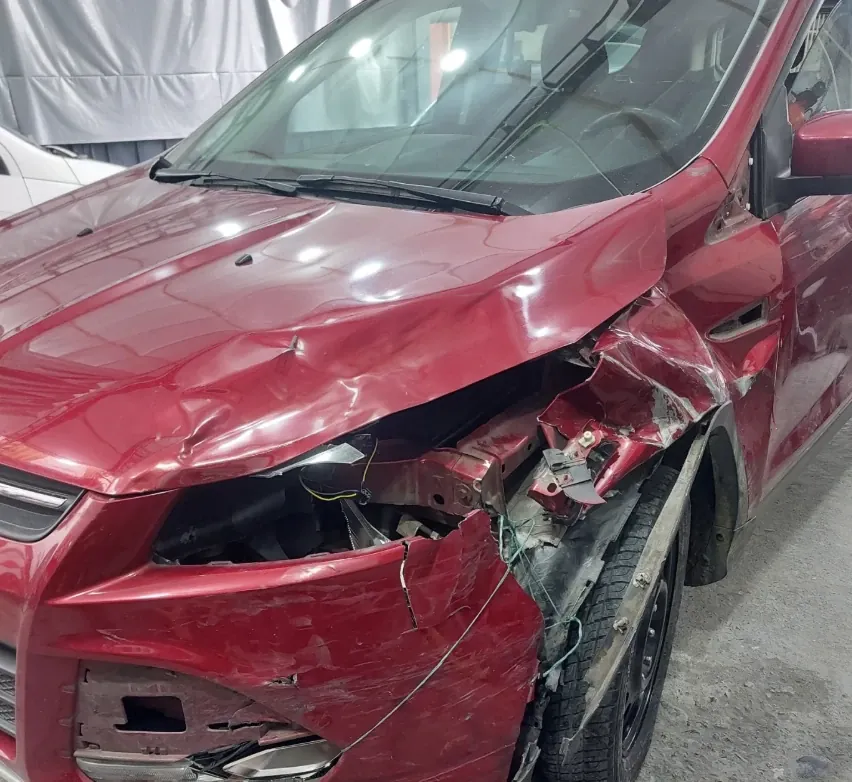 Antes: Ford Escape rojo con el frente destrozado por un choque