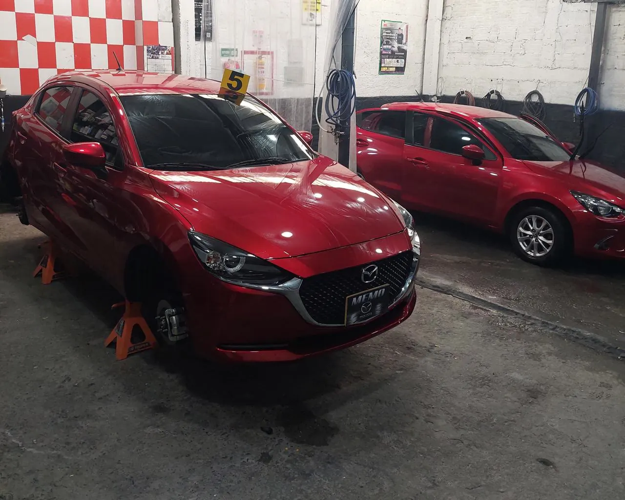 Dos Mazda rojos numerados en turno dentro del taller